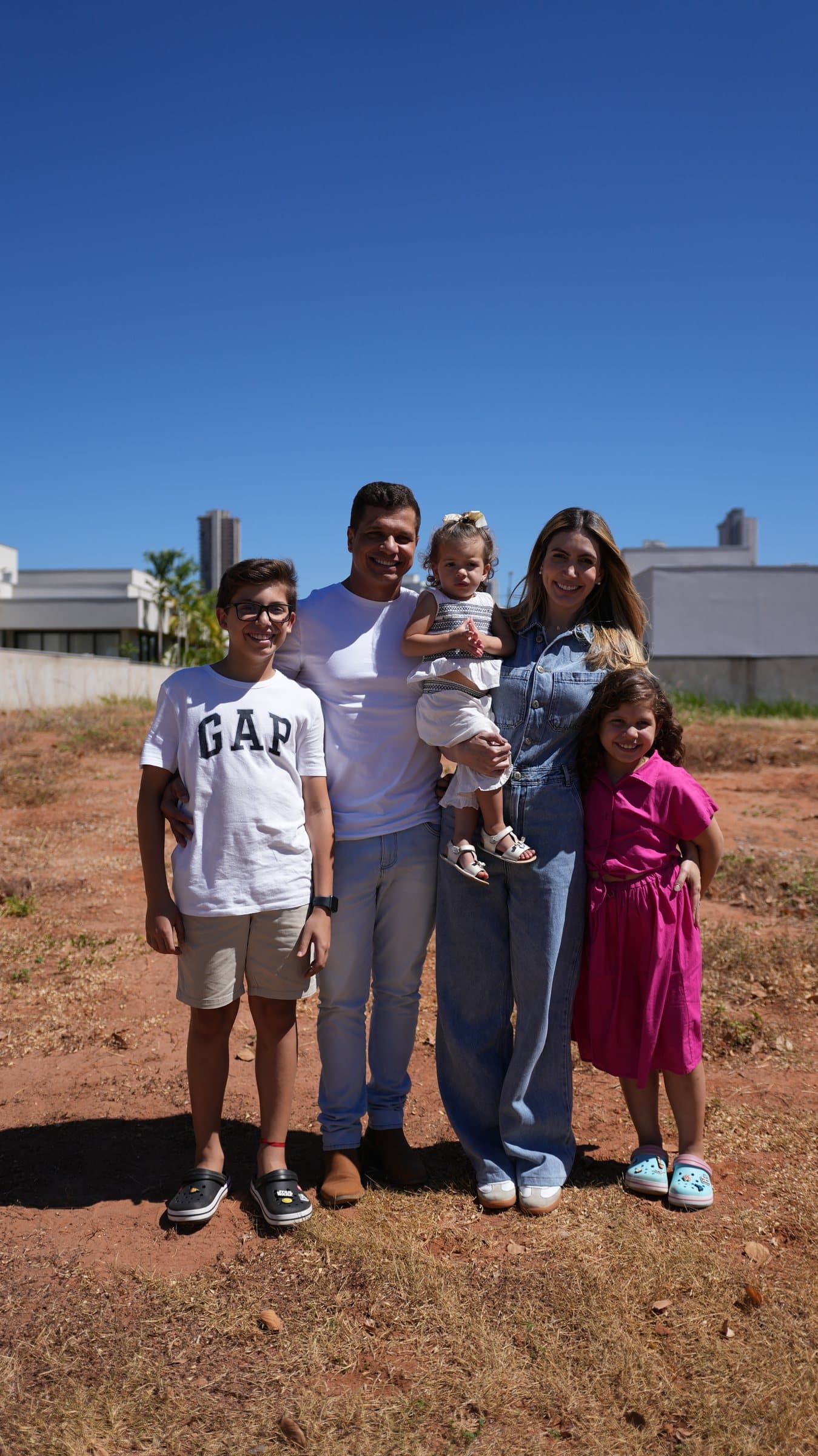 Lucas e Brunna com os filhos no terreno de uma obra